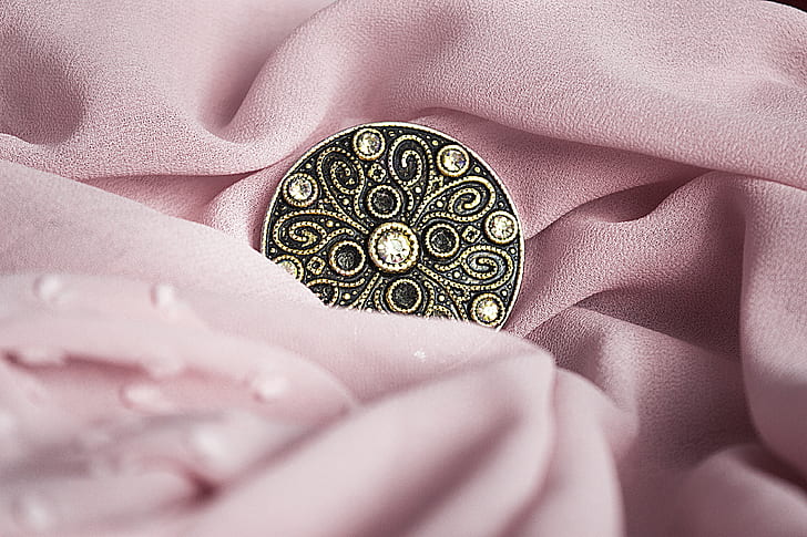 round bronze button on pink textile