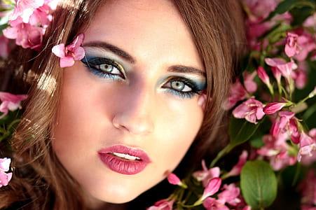 woman wearing eyeshadow surrounded with pink petal flower