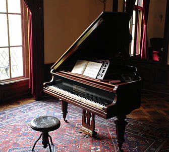 photography of brown wooden grand piano with chair