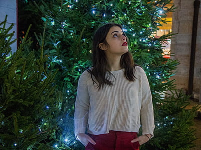 Woman Wearing White Sweater With Red Skirt Near Green Christmas Tree