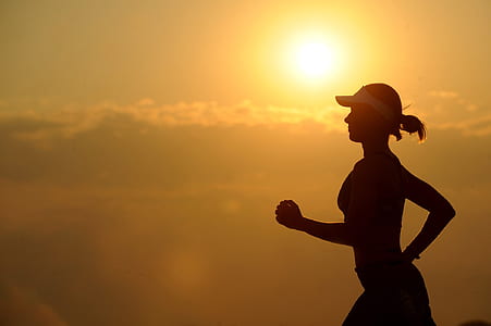 silhouette of woman running during sunset