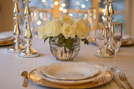 white roses with clear glass champagne flute and white ceramic plate