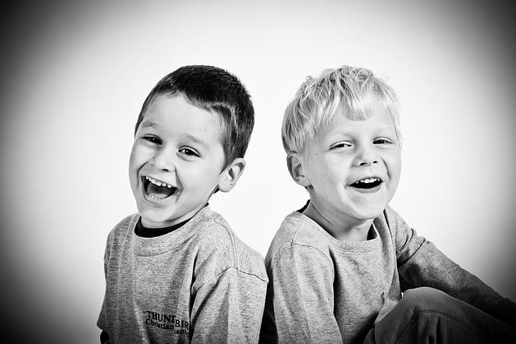 two boys smiling grayscale photography