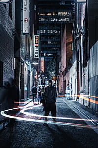 man wearing black jacket on street during nightime
