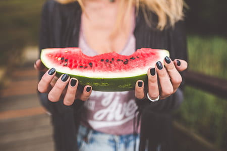 woman holding slice of watermelon