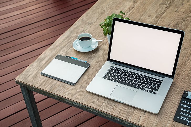 Download Royalty-Free photo: MacBook Pro on brown wooden table ...