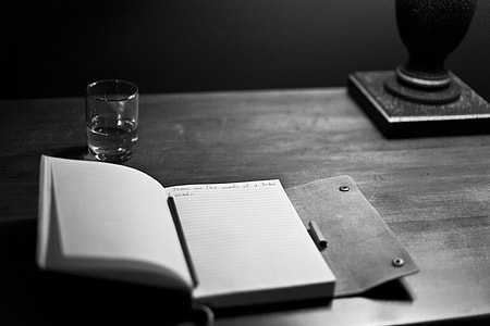 white opened notebook on black table