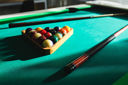 Billiard balls on green table with billiard cue