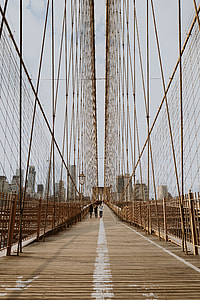 three person standing on bridge
