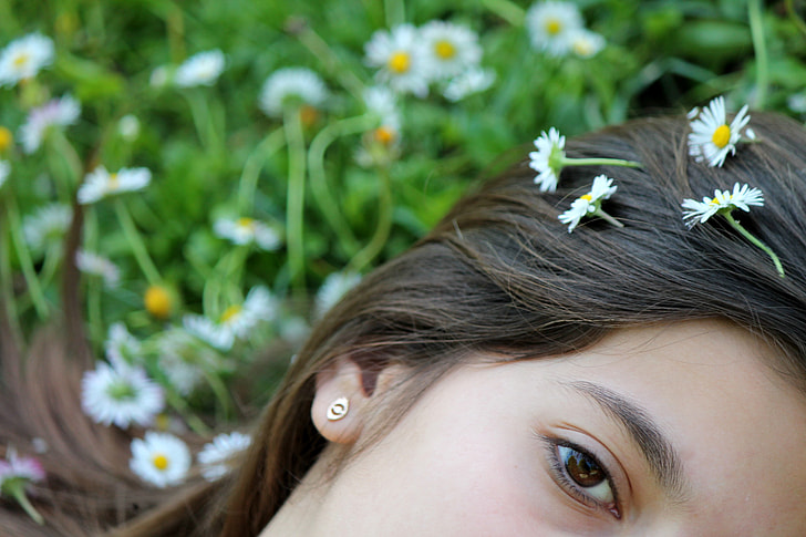 woman with white chamomile flower on hair