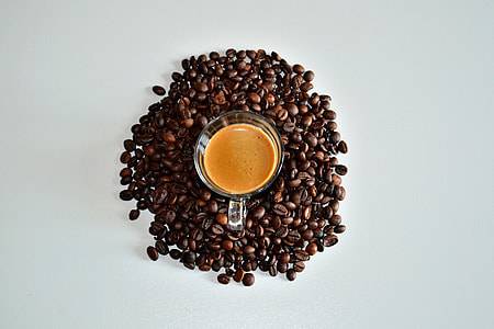 Overhead shot of coffee cup surrounded by coffee beans