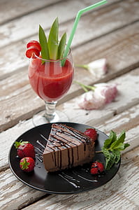 sliced chocolate cake with strawberries and strawberry shake