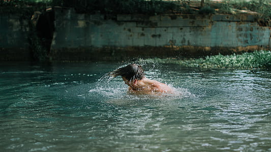 man swimming during daytime