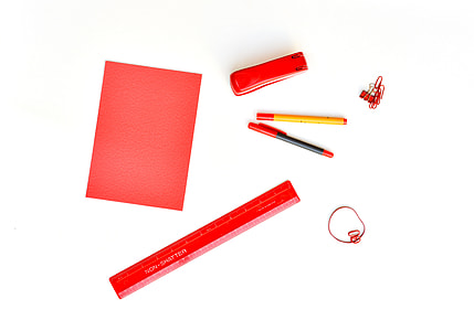 red paper, stapler, two pens, and one box