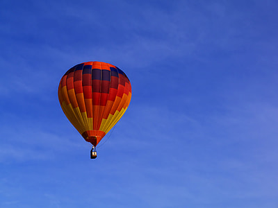 red, orange, and yellow hot air balloon in the sky under blue sky