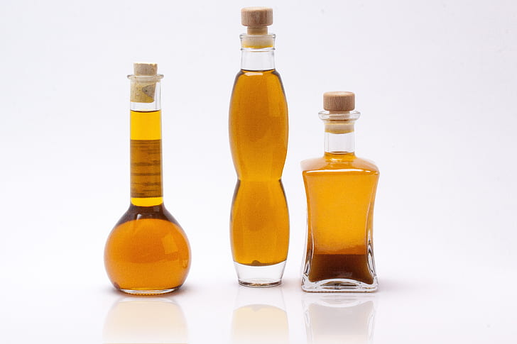 three olive oils on clear glass bottles