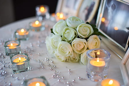 white petaled flower bouquet near clear glass candle holders