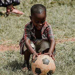 boy wearing plaid shirt holding soccer ball