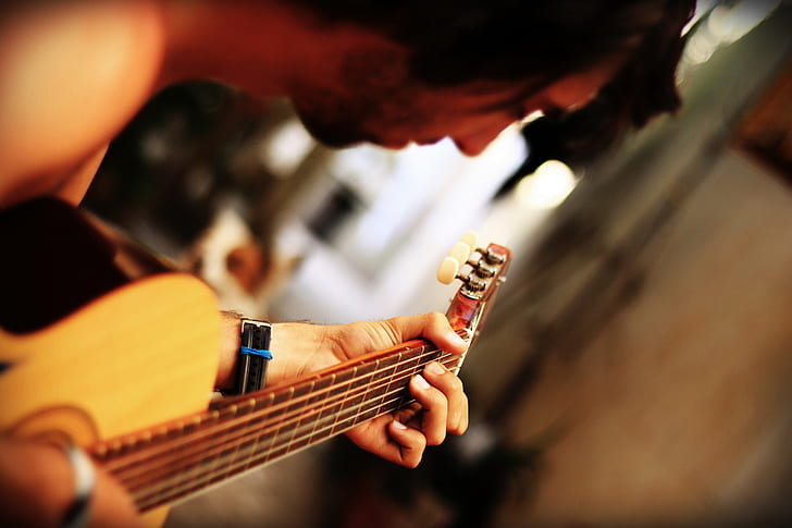 photo of person playing acoustic guitar