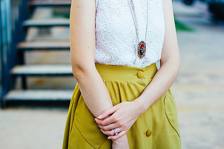 woman wears white sleeved shirt with yellow skirt