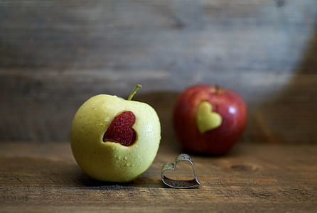 yellow and red apples on brown surface