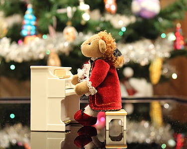 brown bear plush toy playing piano