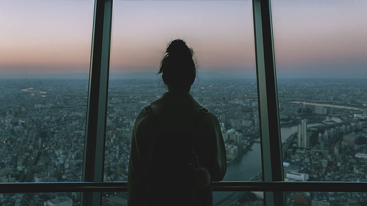 woman looking through window in city photography