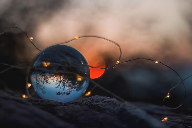 selective focus photography of brown string light and glass ball paperweight during sunset photo