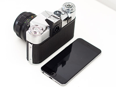 black and silver camera and space gray iPhone 6 on table