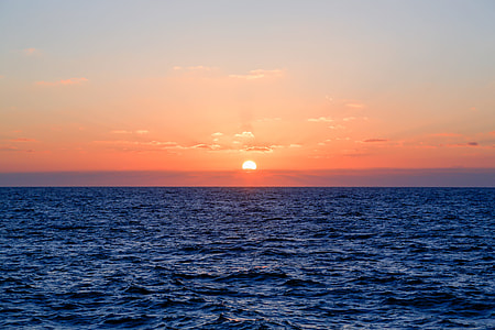sunset at horizon over body of water