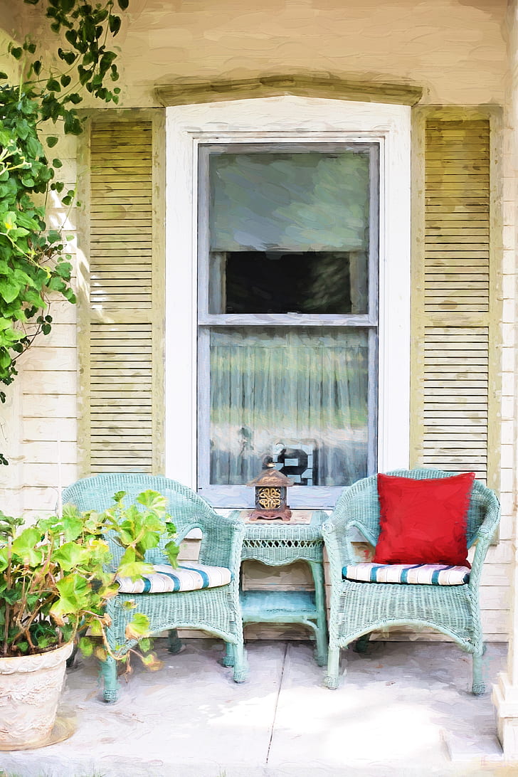 two green wicker armchairs near sash window