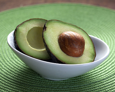 photo of sliced avocado fruits in white ceramic bowl