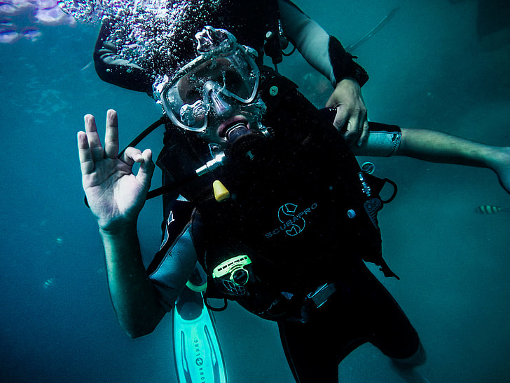 person wearing scuba suit under water