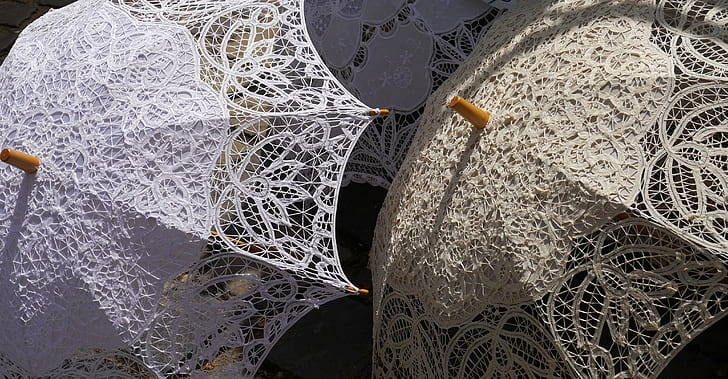 photo of two beige and white lace umbrellas