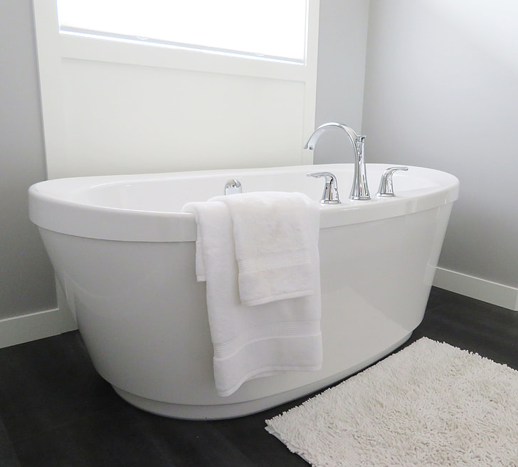white enamel bathtub with towel