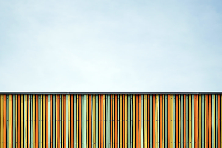 orange, teal, and yellow wooden fence at daytime