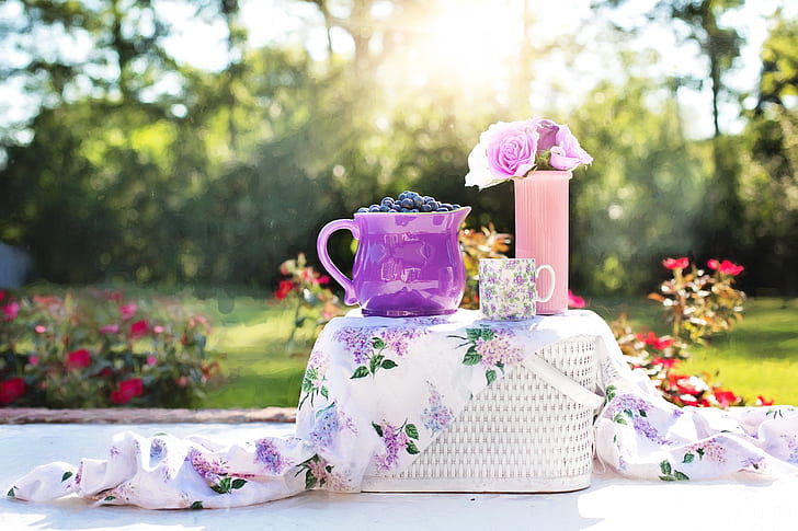 purple ceramic pitcher on white wicker picnic basket during daytime