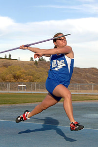 woman holding metal spear and about to throw while running