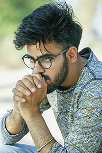 man in grey long-sleeved shirt sitting and wearing eyeglasss