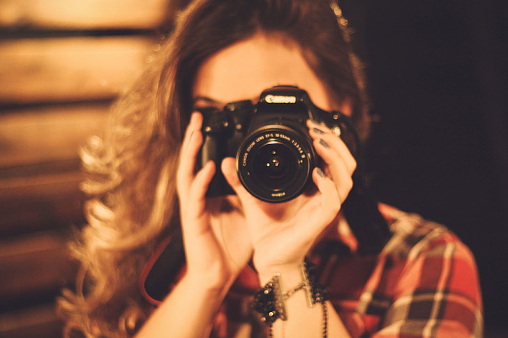 Woman photographer with long hair using a camera