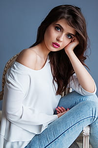 woman in white long-sleeved top and blue jeans