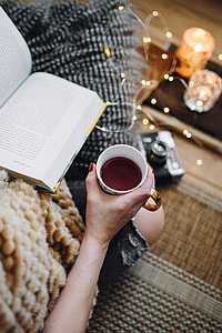 Woman drinking tea and reading book