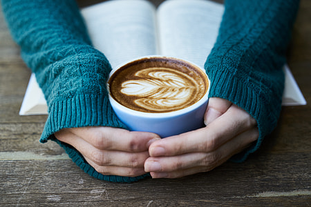 person holding blue ceramic coffee cup