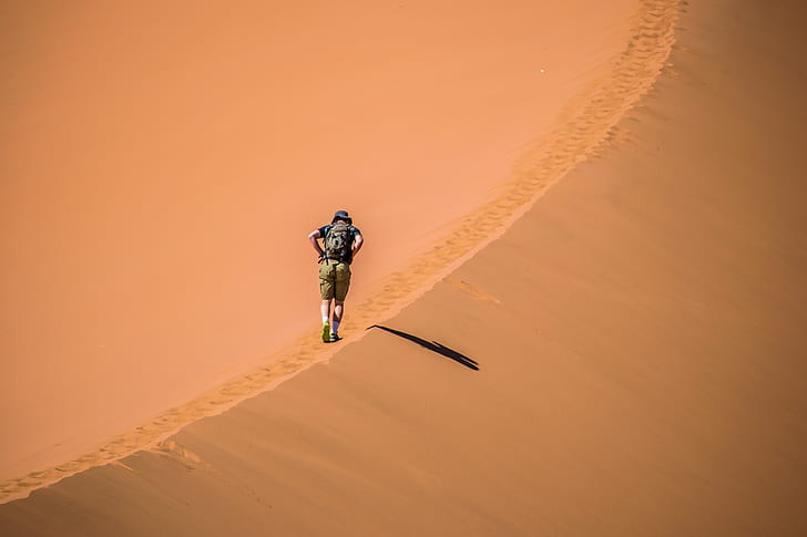 man walking in desert during daytime