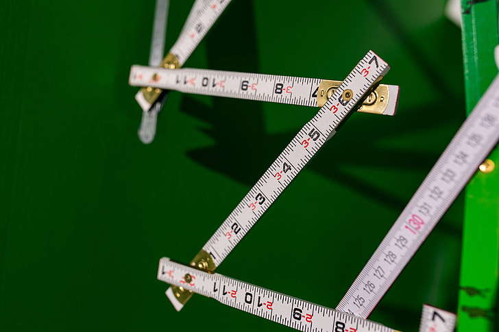 Extandable wooden ruler on a green background
