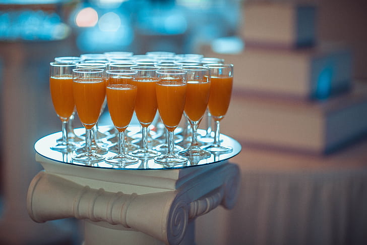 cocktail glasses filled with orange liquid content