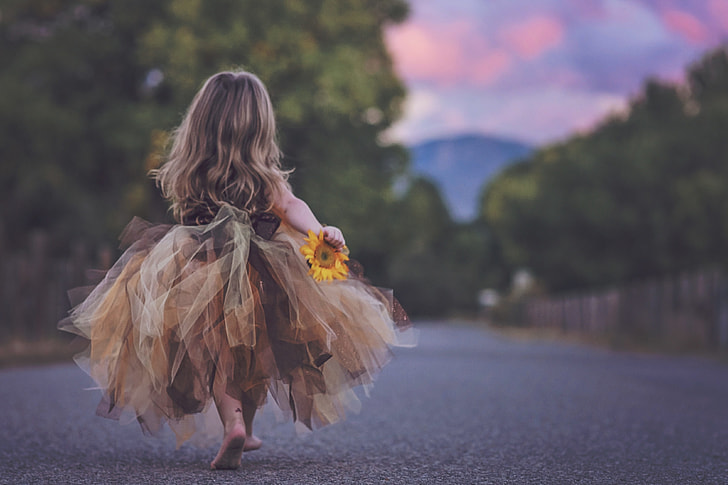 shallow focus photography of child in beige dress