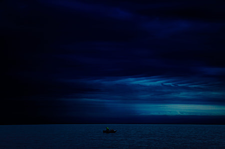 boat on body of water under blue sky