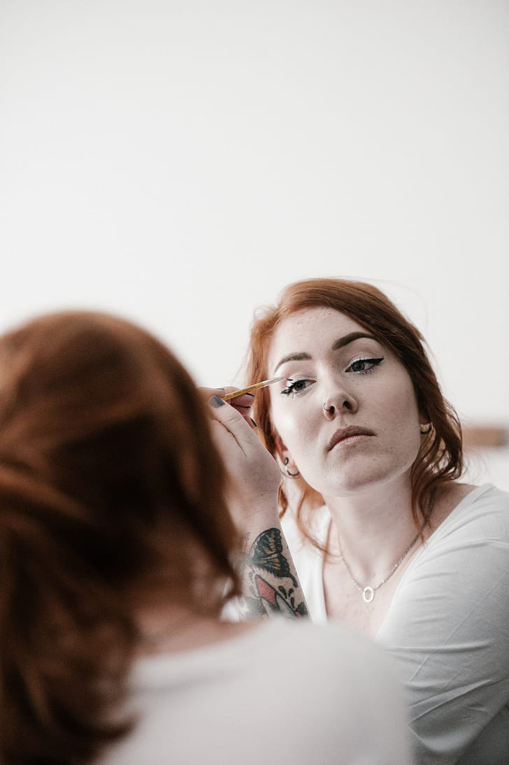 woman putting liquid eyeliner photograph
