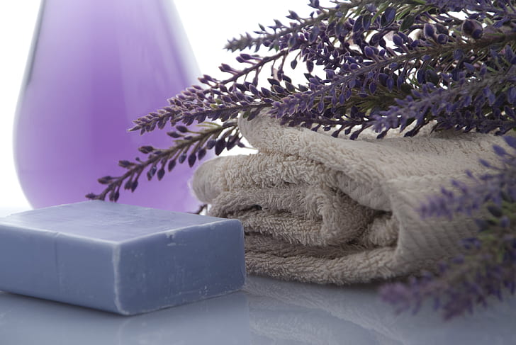 shallow focus photography of purple soap bar beside gray textile